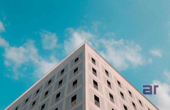 Modern building infrastructure under blue sky, highlighting Skyreach and NexCorp’s innovations in aerospace infrastructure and smart urban development led by Atul Raj.
